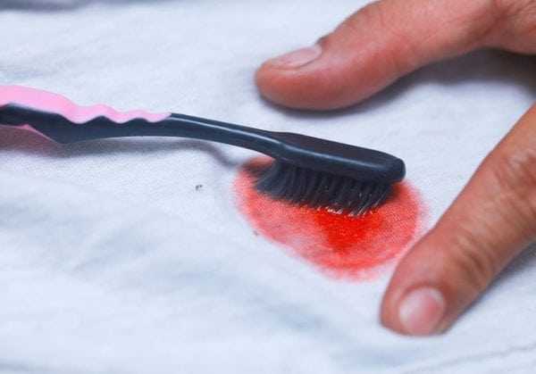 Выведение краски с одежды зубной щеткой и пятновыводителем